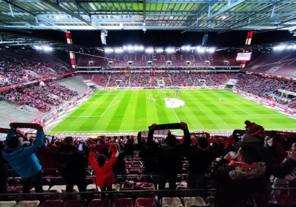 Blick ins nur teilweise gefüllte Müngersdorfer Stadion, in dem Köln-Fans ihre Schals hochhalten.