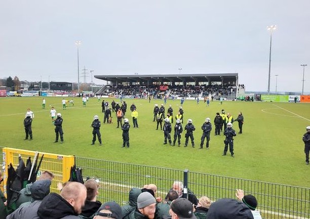 Preußen Münster-Fans im Gästeblock in Velbert, Polizei auf dem Spielfeld.