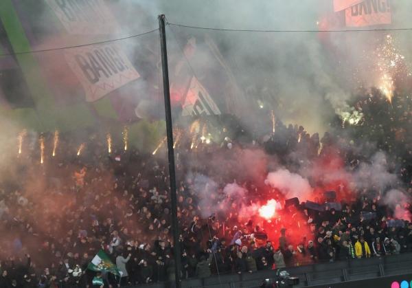 Pyrotechnik, Blockfahne und zahlreiche Feyenoord-Fans in einem vollbesetzten Stadion.
