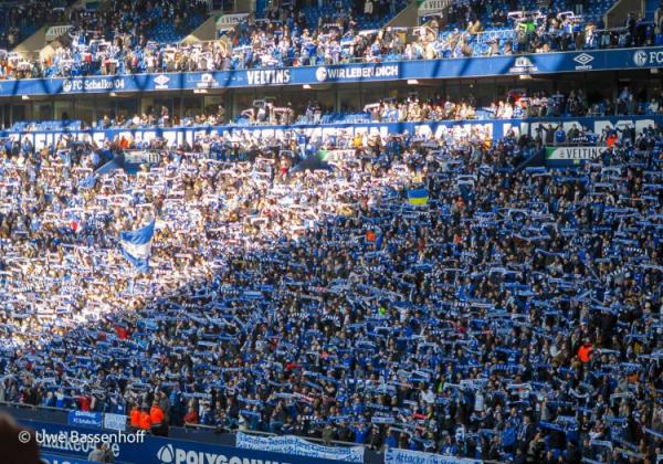 Schalke-Fans halten in der Nordkurve ihre Schals hoch. Kurzfristig darf die Arena auf Schalke beim Heimspiel gegen Hannover erstmals wieder komplett ausgelastet werden.