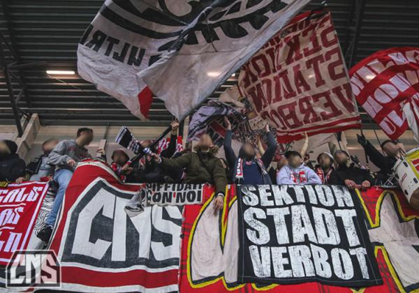 Kölner Ultras hinter "Diffidati con noi"- und "Sektion Stadtverbot"-Zaunfahnen.