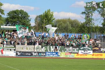 VfB Lübeck-Fans beim Auswärtsspiel in Hildesheim. Die CA-Fahne hängt über dem UKL-Banner.