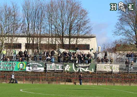 VfB Lübeck-Fans hinter ihren Zaunfahnen beim Auswärtsspiel in Hamburg.