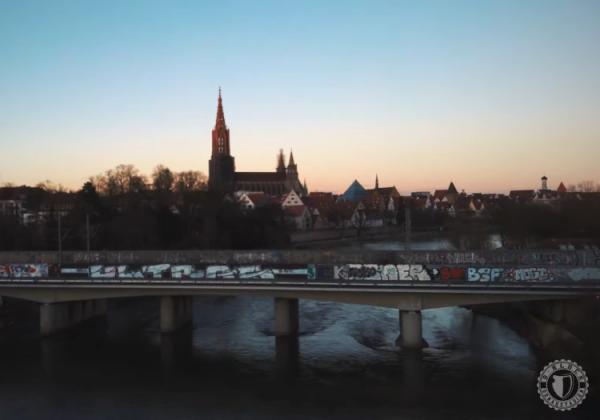 Der Ulmer Münster im Hintergrund, davor ein Ultras-Graffiti auf einer Brücke.