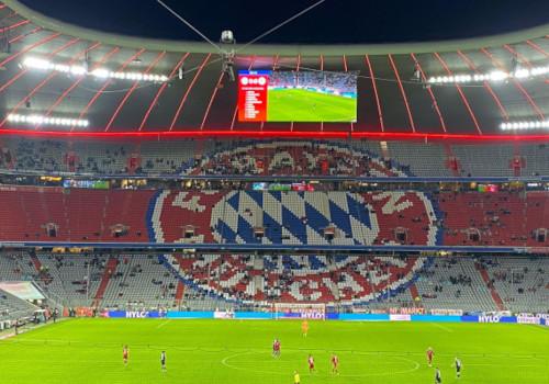 FC Bayern-Wappen im dortigen Stadien. Die Sitze sind nur zu geringen Teilen mit Fans gefüllt.