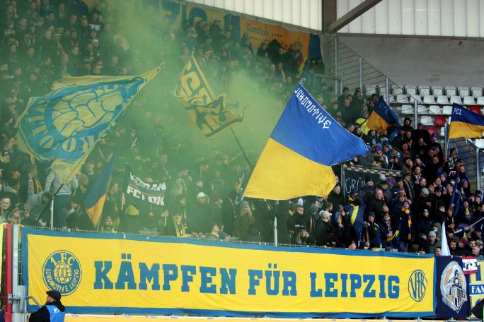 Lok Leipzig-Fans beim Auswärtsspiel in Erfurt hinter einer "Kämpfen für Leipzig"-Zaunfahne.