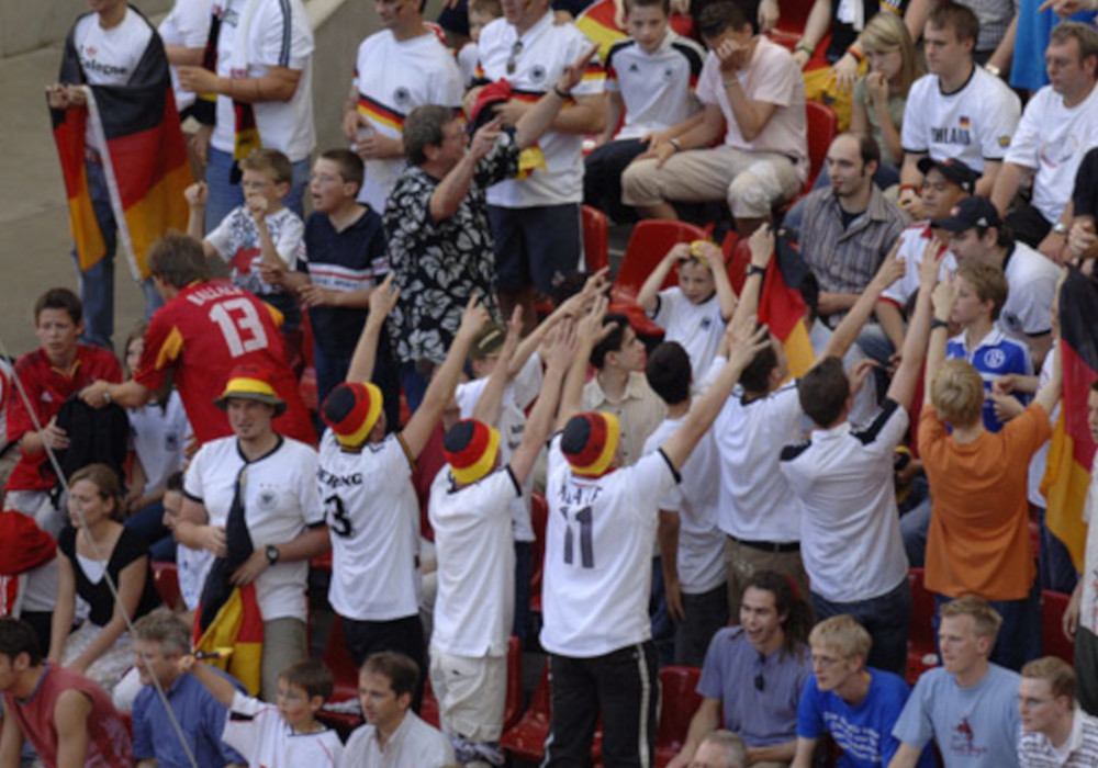 Deutsche Fans die im Jahr 2004 auf Sitzplätzen versuchen Stimmung zu machen.
